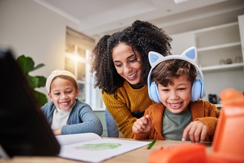Image showing young woman with two children, one child has large blue headphones on
